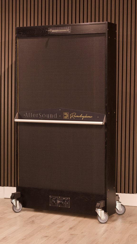 Reverbophone in a black oak frame with a black grille, standing on castors against a slatted timber wall
