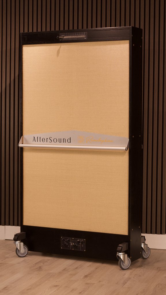 Reverbophone in a black oak frame with a blond grille, standing on castors against a slatted timber wall