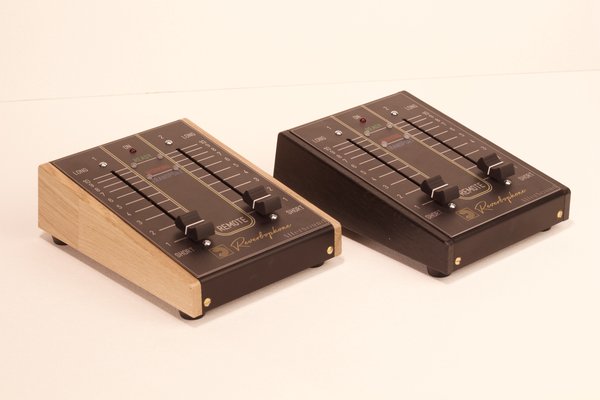 Two Remote Control units side by side, one in honey oak and one in black oak, each with short-to-long decay faders