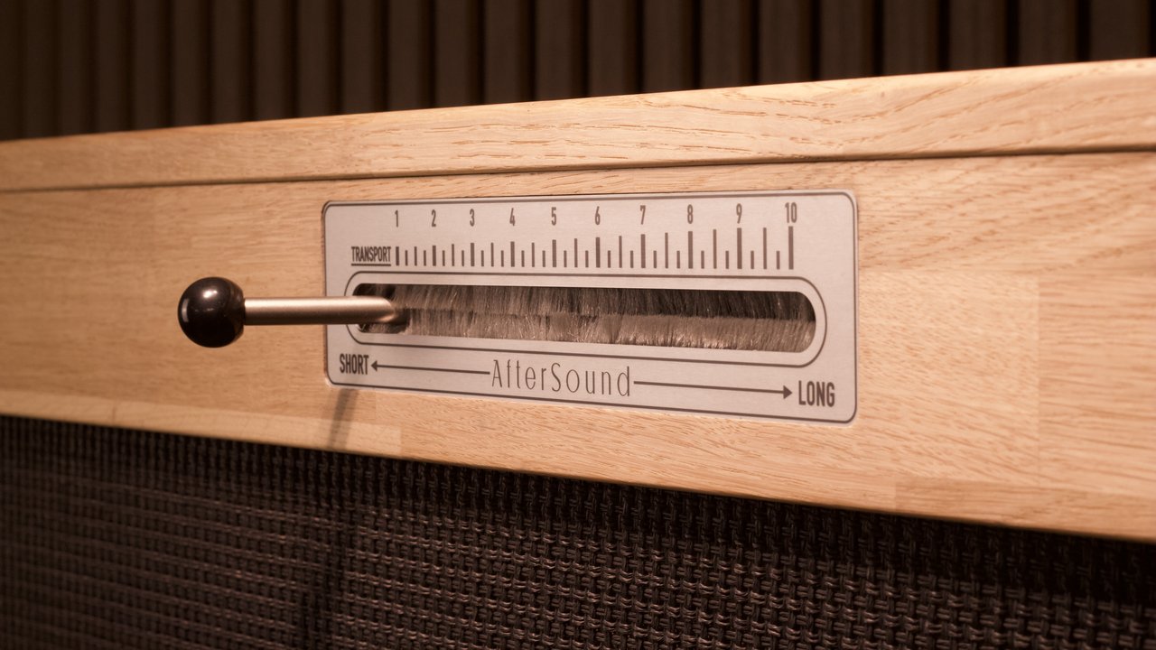 The Reverbophone decay lever set into a honey oak cabinet, marked short to long across a numbered transport scale